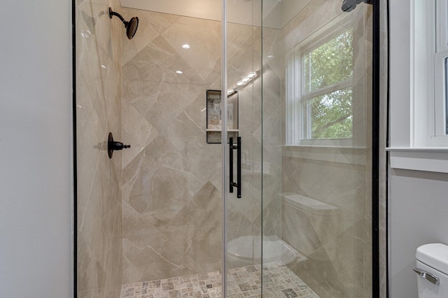 bathroom featuring toilet and a shower with door