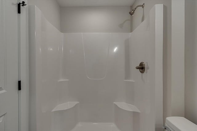 bathroom featuring toilet and a shower