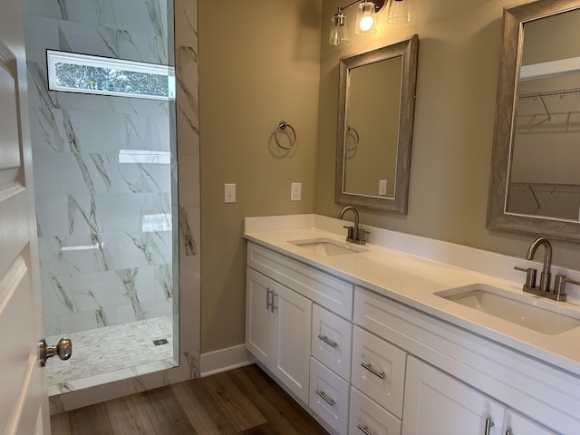 bathroom featuring vanity, a tile shower, and hardwood / wood-style flooring