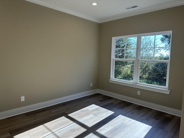 empty room with ornamental molding and dark hardwood / wood-style flooring