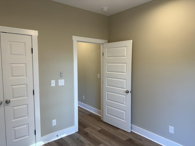 unfurnished bedroom featuring dark hardwood / wood-style floors and a closet