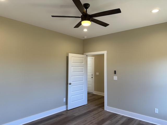 spare room featuring dark wood-type flooring and ceiling fan