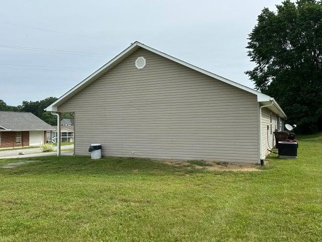 view of side of home with a lawn