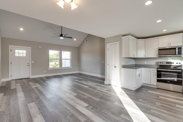 kitchen with light hardwood / wood-style floors, white cabinets, lofted ceiling, stainless steel appliances, and ceiling fan