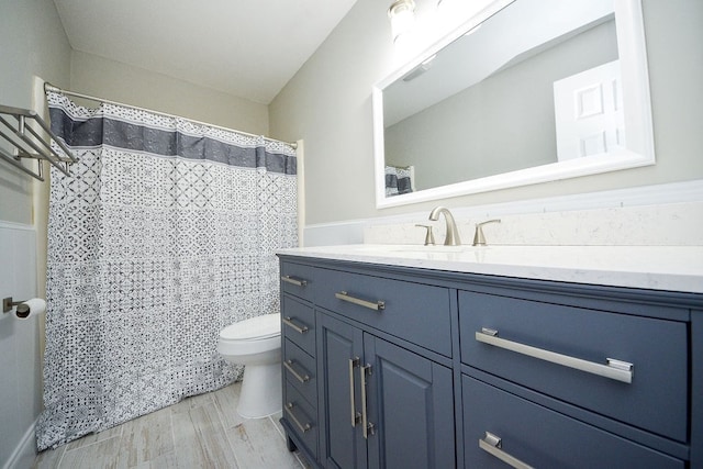 bathroom with wood-type flooring, vanity, toilet, and curtained shower