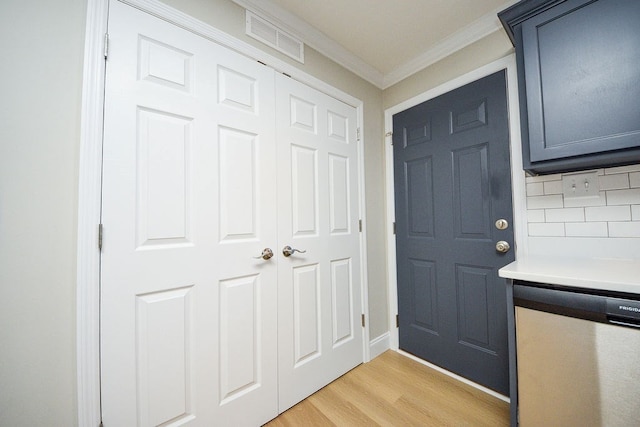 interior space featuring dishwasher, light wood-type flooring, crown molding, and decorative backsplash