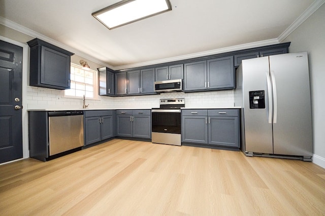 kitchen featuring stainless steel appliances, backsplash, ornamental molding, and light hardwood / wood-style flooring