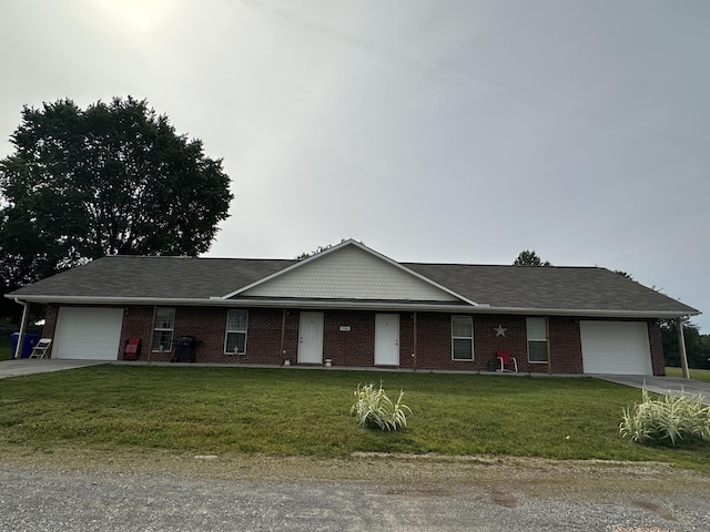 ranch-style home with an attached garage, concrete driveway, a front lawn, and brick siding