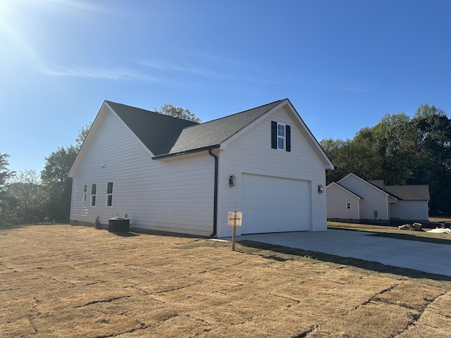 view of side of home with central AC and a garage