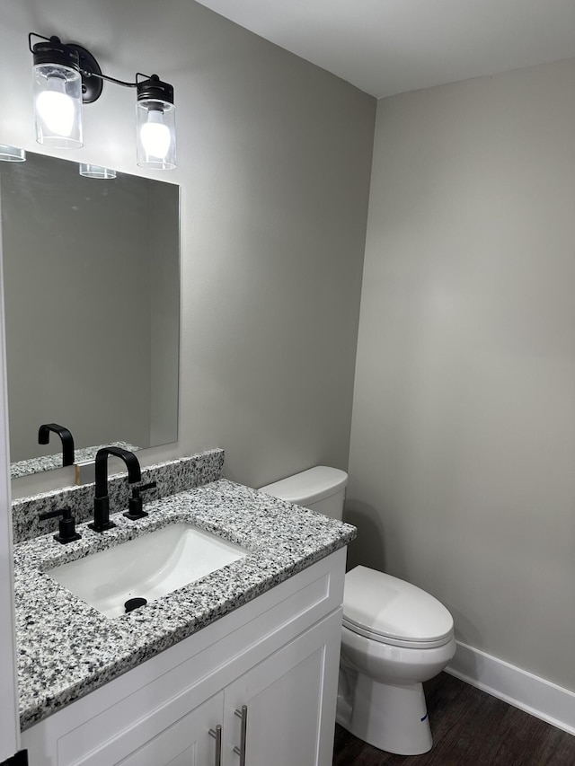 bathroom with vanity, hardwood / wood-style floors, and toilet