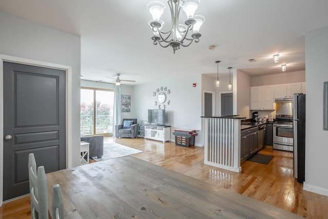 dining room featuring light hardwood / wood-style floors and ceiling fan with notable chandelier