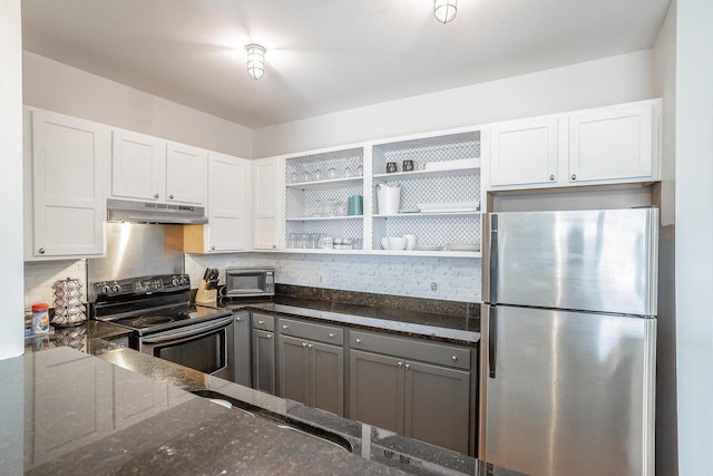 kitchen with dark stone countertops, white cabinetry, and appliances with stainless steel finishes