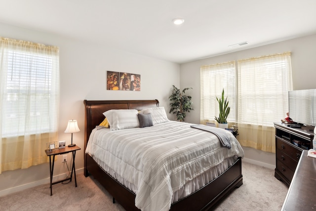 carpeted bedroom featuring multiple windows