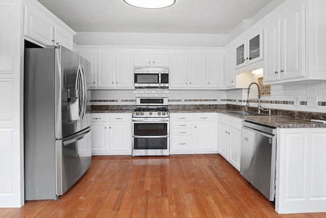 kitchen featuring sink, light hardwood / wood-style flooring, stainless steel appliances, and white cabinets