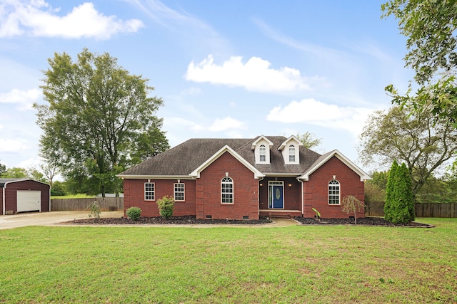 view of front of house featuring a garage, a front lawn, and an outbuilding