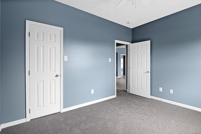 unfurnished bedroom featuring ceiling fan, a textured ceiling, and carpet flooring