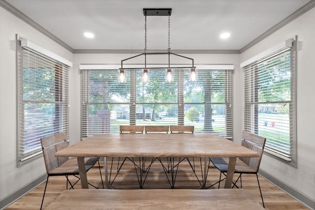 dining room featuring ornamental molding, light wood-type flooring, a chandelier, and plenty of natural light