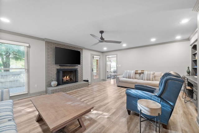 living room with light wood-type flooring, ceiling fan, and a wealth of natural light