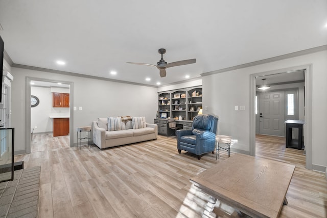 living room with light hardwood / wood-style floors, ceiling fan, and crown molding