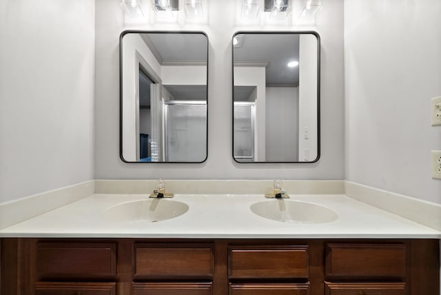 bathroom with vanity, crown molding, and a shower with door