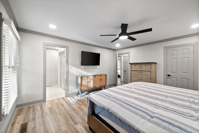 bedroom featuring ceiling fan, ensuite bathroom, light wood-type flooring, and ornamental molding