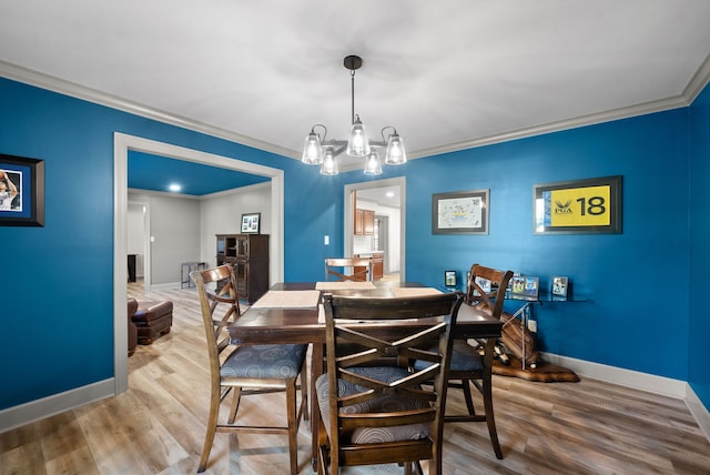 dining room with an inviting chandelier, ornamental molding, and hardwood / wood-style floors