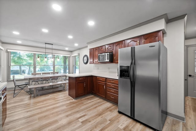 kitchen featuring light wood-type flooring, appliances with stainless steel finishes, hanging light fixtures, and crown molding