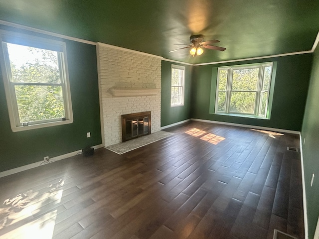 unfurnished living room with a fireplace, dark wood-type flooring, and plenty of natural light