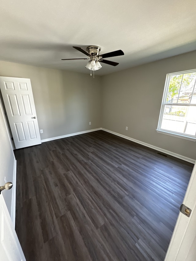 spare room featuring ceiling fan and dark wood-type flooring