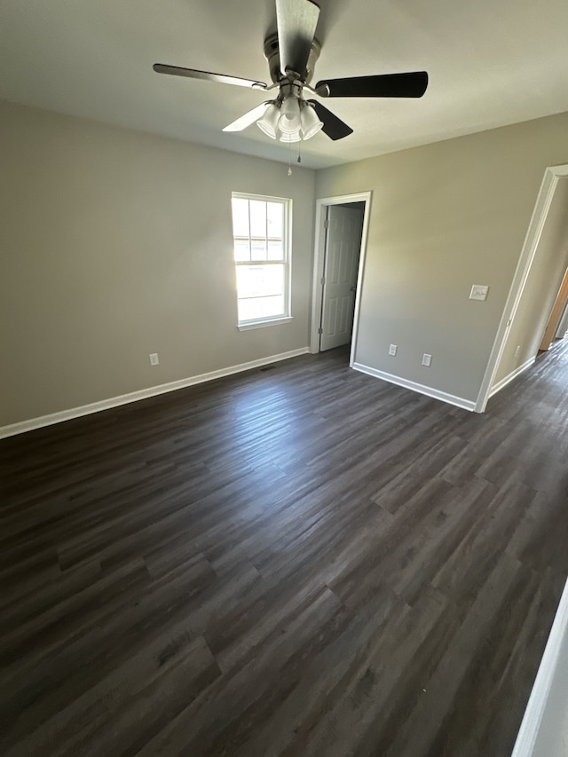 spare room with ceiling fan and dark wood-type flooring