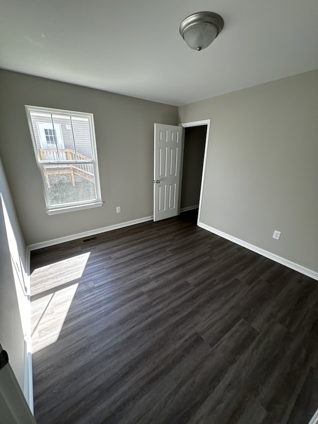 spare room featuring dark wood-type flooring