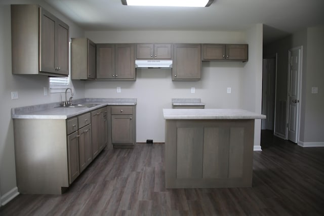 1603 Mantlo St, Springfield, TN 37172 - kitchen with a sink, under cabinet range hood, dark wood-style flooring, baseboards, and a kitchen island
