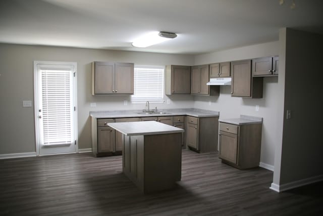1603 Mantlo St, Springfield, TN 37172 - kitchen with under cabinet range hood, a kitchen island, baseboards, dark wood-style floors, and a sink