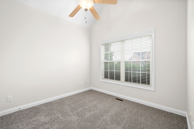 carpeted spare room featuring baseboards, visible vents, vaulted ceiling, and a ceiling fan