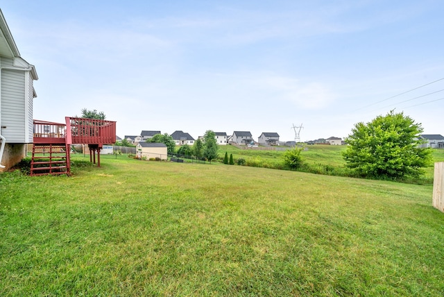 view of yard featuring fence, a deck, and stairs