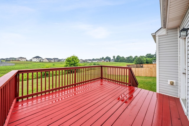 wooden terrace featuring a residential view, fence, and a yard