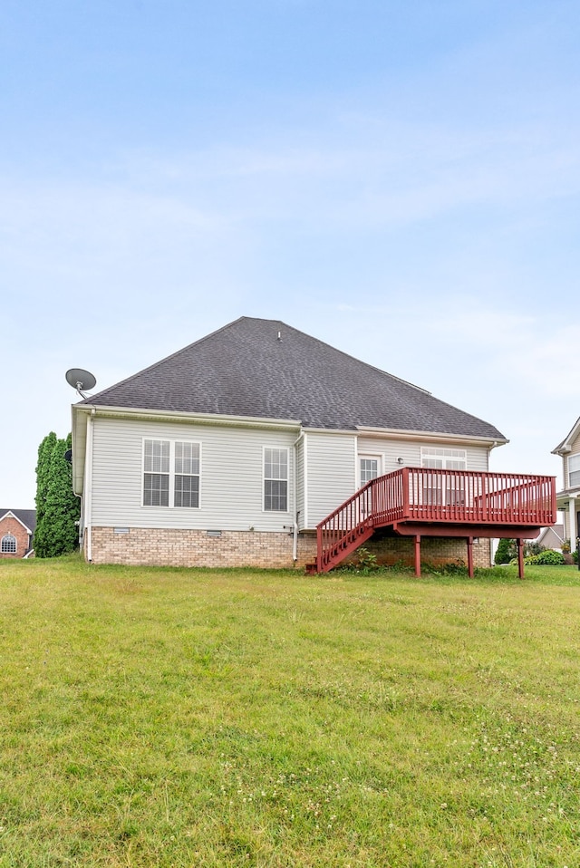 back of property with roof with shingles, a lawn, and a wooden deck