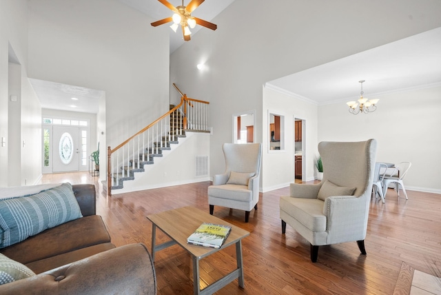 living area featuring crown molding, visible vents, stairway, wood finished floors, and baseboards