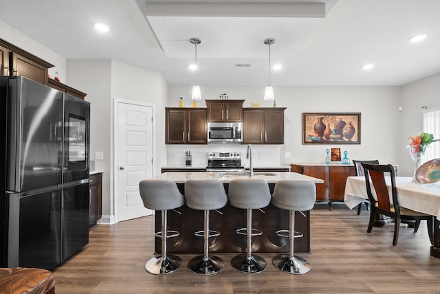 kitchen featuring pendant lighting, stainless steel appliances, tasteful backsplash, and dark hardwood / wood-style flooring