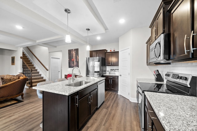 kitchen featuring a kitchen island with sink, tasteful backsplash, dark wood-type flooring, sink, and stainless steel appliances