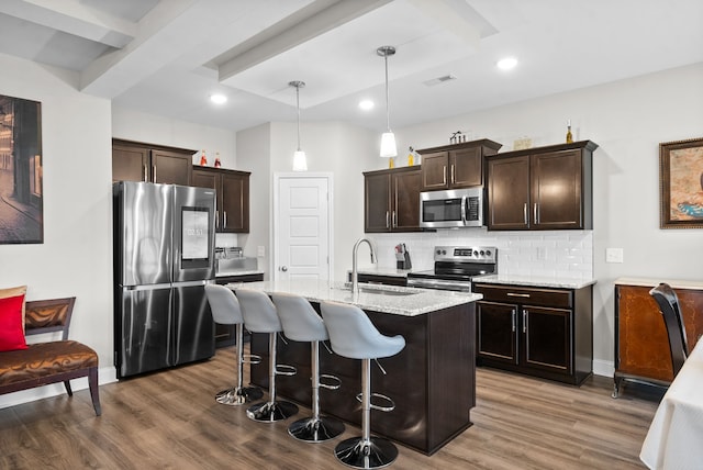 kitchen with stainless steel appliances, hanging light fixtures, sink, and dark hardwood / wood-style flooring