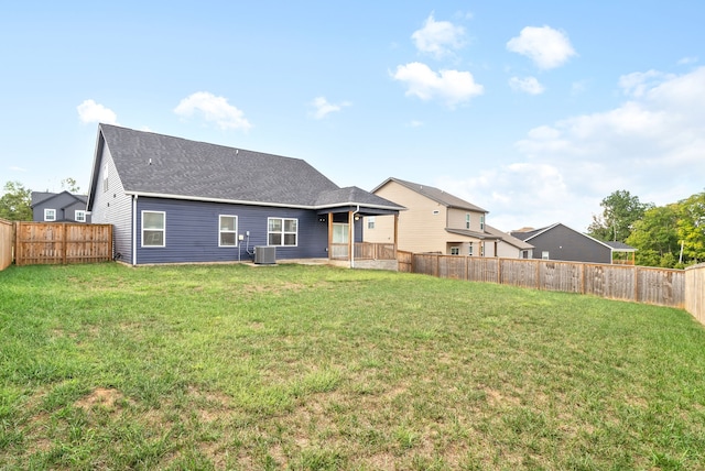 back of property featuring cooling unit and a yard