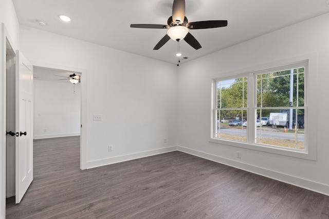 empty room with ceiling fan and dark wood-type flooring