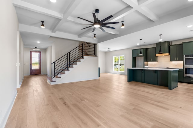 kitchen featuring light wood-type flooring, backsplash, beam ceiling, decorative light fixtures, and a kitchen island