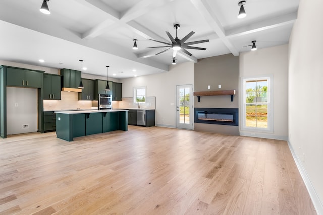 kitchen featuring decorative backsplash, stainless steel appliances, ceiling fan, decorative light fixtures, and a center island