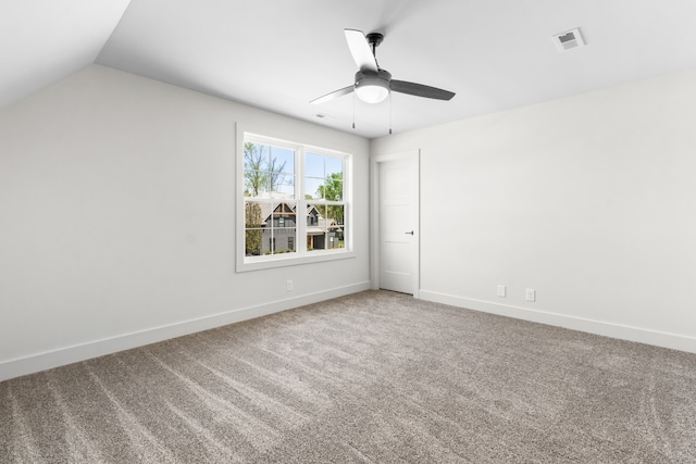 spare room featuring ceiling fan, carpet floors, and vaulted ceiling