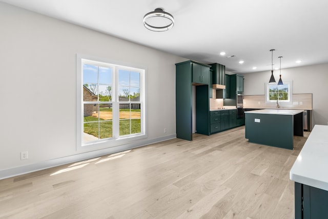 kitchen with backsplash, premium range hood, a center island, light hardwood / wood-style floors, and hanging light fixtures