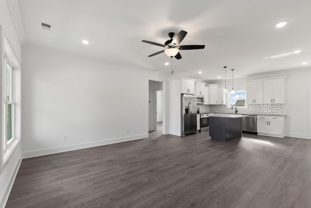 kitchen featuring appliances with stainless steel finishes, a kitchen island, pendant lighting, and white cabinetry