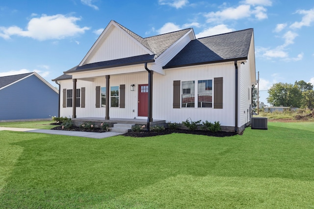 view of front of home featuring a front lawn, central AC unit, and covered porch