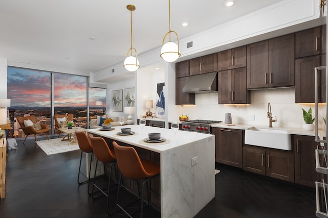 kitchen featuring pendant lighting, dark parquet floors, sink, a kitchen bar, and decorative backsplash